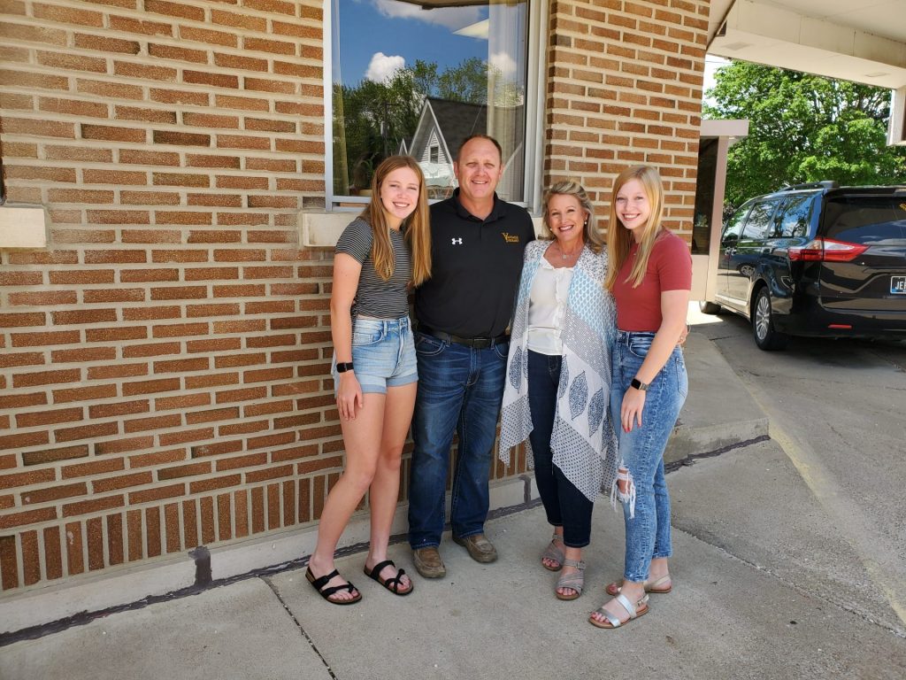 The VanDaele Family consisting of parents, Chad and Amber, as well as their two daughters standing outside of the future Empowered Energy building.