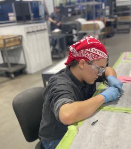 Teenage student working on a die cut at Geater Machining and Manufacturing.